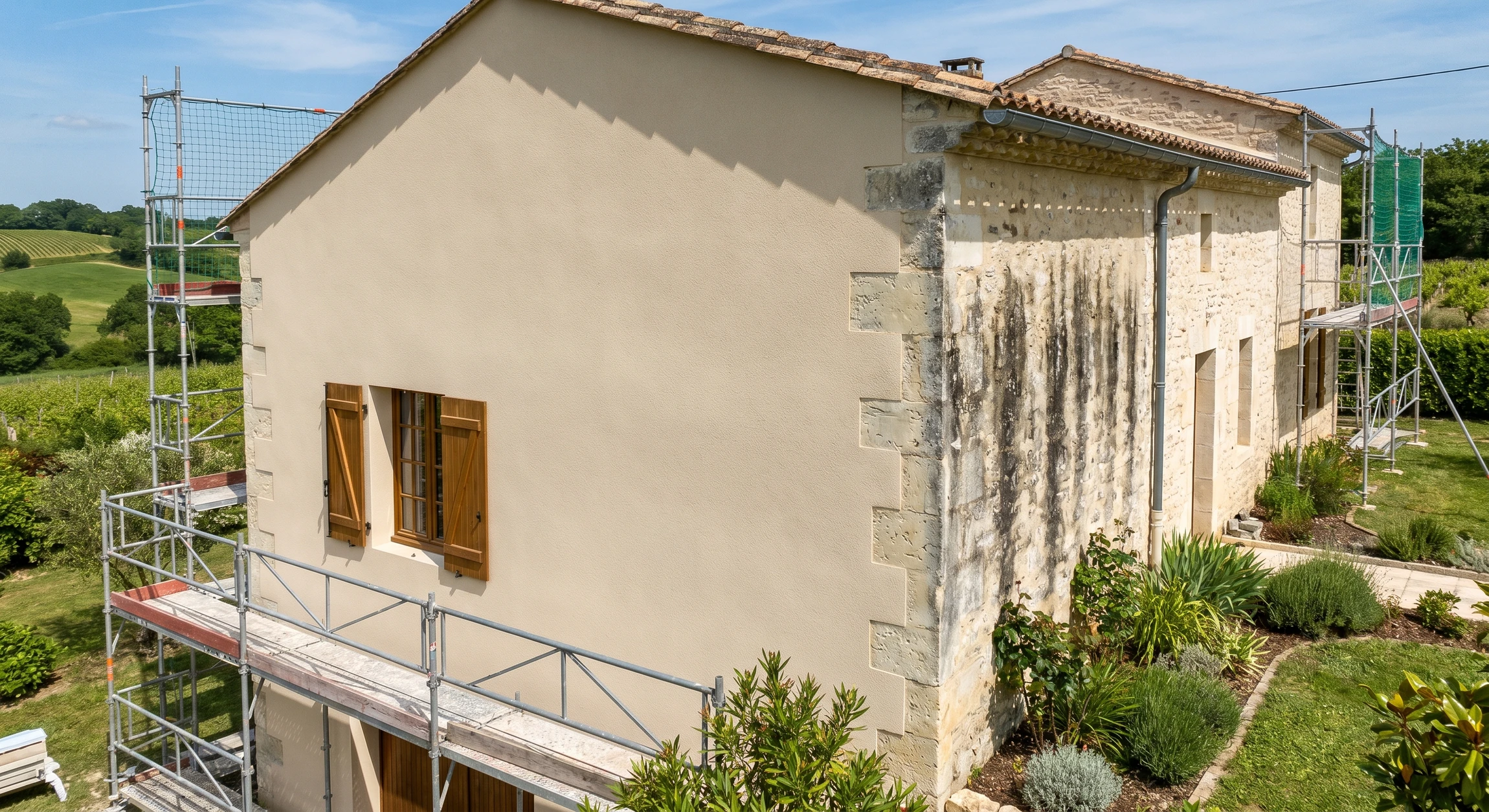 Photographie professionnelle d'une façade de maison individuelle clairement ravalisée et transformée, montrant une paroi nettoyée, lisse et uniformément couverte d'un enduit de façade fraîchement appliqué, avec un rendu de qualité évident. La façade doit être bien visible et pouvoir être comparée à l'état antérieur (si possible par contraste de couleur ou de texture). La maison doit être photographiée en conditions d'éclairage naturel favorable pour valoriser la qualité du travail réalisé. L'environnement doit être résidentiel et réaliste, représentatif des zones d'intervention de l'entreprise (façade de maison de caractère ou classique renovée).