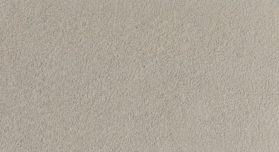 Surface en sable fin et uniforme, texture granuleuse naturelle avec quelques petits débris organiques dispersés