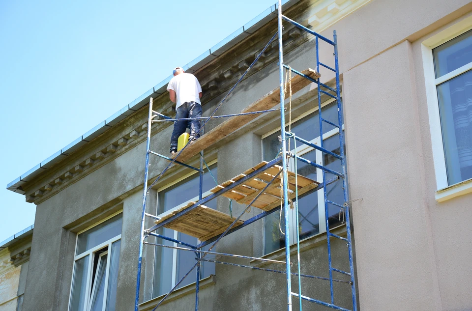 Chantier de rénovation extérieure d'un bâtiment résidentiel avec échafaudage métallique tubulaire multi-niveaux